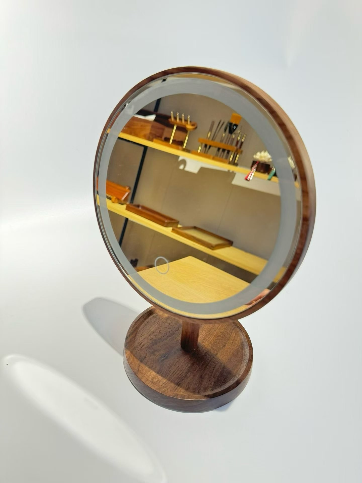 Wood-framed tabletop vanity mirror with a circular touch marking and its light unlit